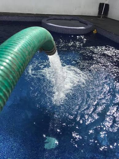 Manguera suministrando agua a una piscina